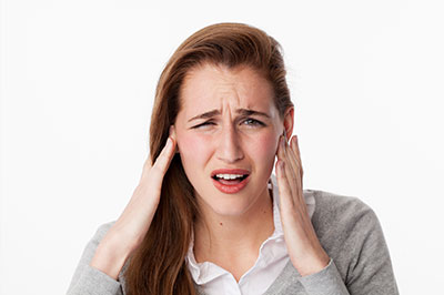 The image shows a woman with her hand on her head, likely in disbelief or shock.