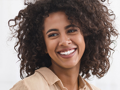 Woman with curly hair, smiling at the camera.